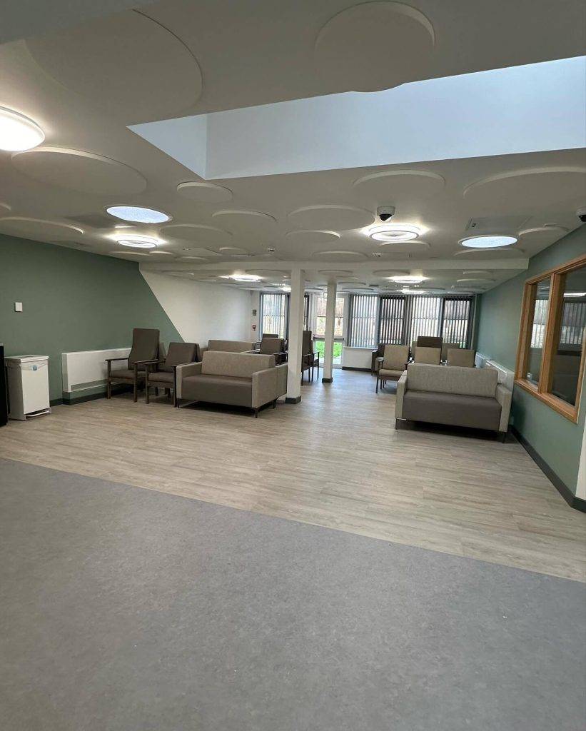 Professional decorator painting a care home corridor in Nottingham